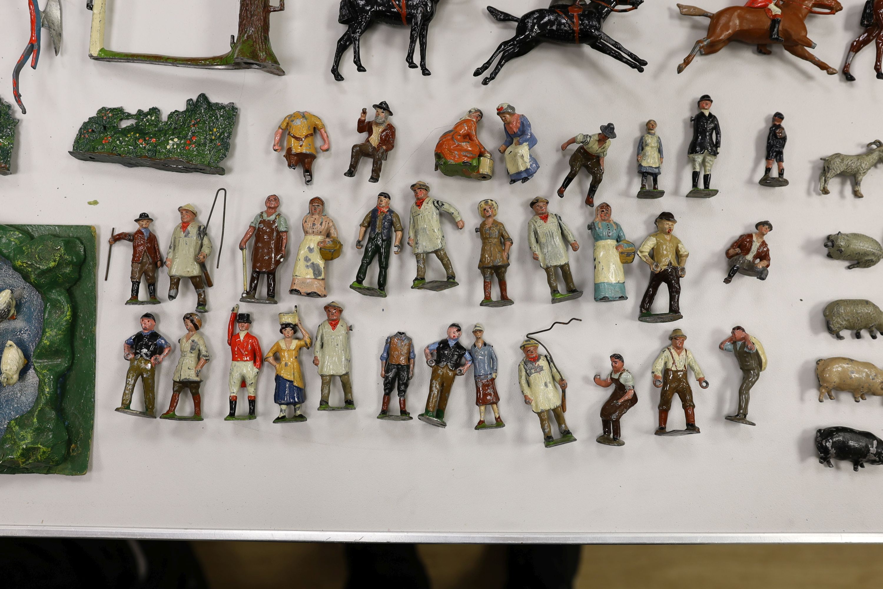 A collection of mainly Britains painted lead figures and animals, including huntsmen and hounds, farm workers, animals and wooden buildings